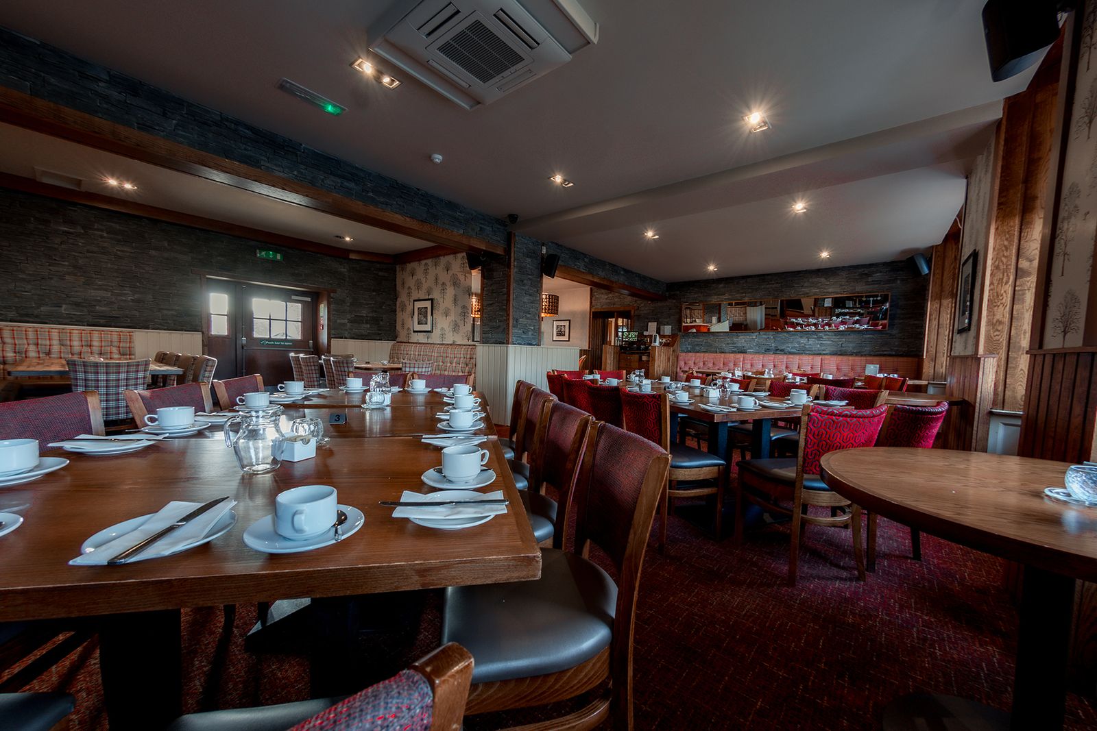 The main dining room at The Balgarth Pines, long tables set with cups and saucers for a large party