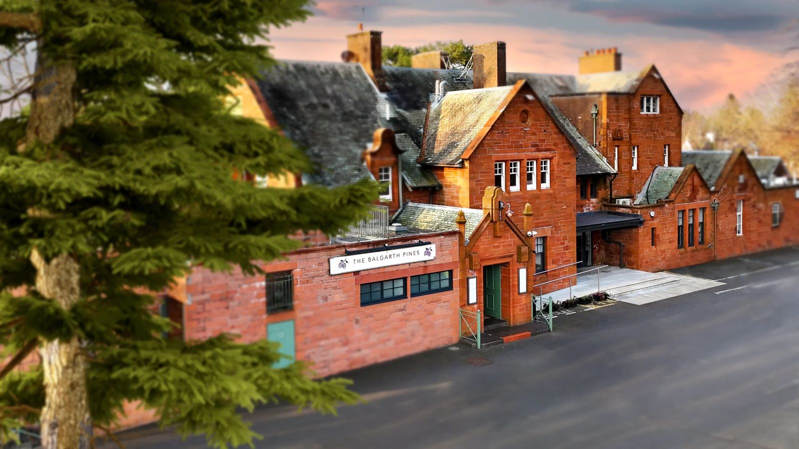 The Balgarth Pines, a red sandstone villa on Dunure Road in Doonfoot, Ayr, at dusk